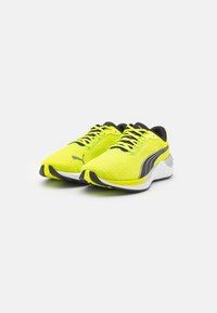 Zapatillas deportivas de color verde lima con una parte superior texturizada, detalles en negro y una suela blanca. Presentan un diseño de cordones y un distintivo logo de Puma en el lateral.