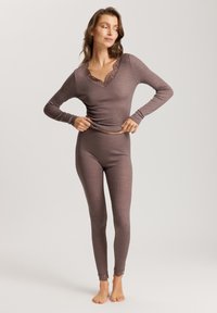 Maglia termica a maniche lunghe marrone con scollo in pizzo, abbinata a leggings marroni con bordo in pizzo alle caviglie. Tessuto morbido a costine.