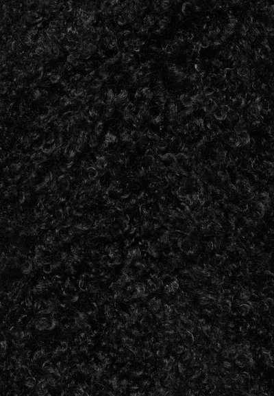 Μαύρη σγουρή υφή υφάσματος με πυκνές, μαλακές ίνες που δημιουργούν μια αφράτη εμφάνιση. Η επιφάνεια είναι γυαλιστερή και ελαφρώς ανακλαστική σε ορισμένα σημεία.