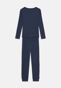 Camiseta de manga larga en color navy y pantalones a juego, hechos de una tela suave y elástica. La camiseta presenta un cuello redondo; los pantalones tienen una cinturilla elástica y puños ajustados.