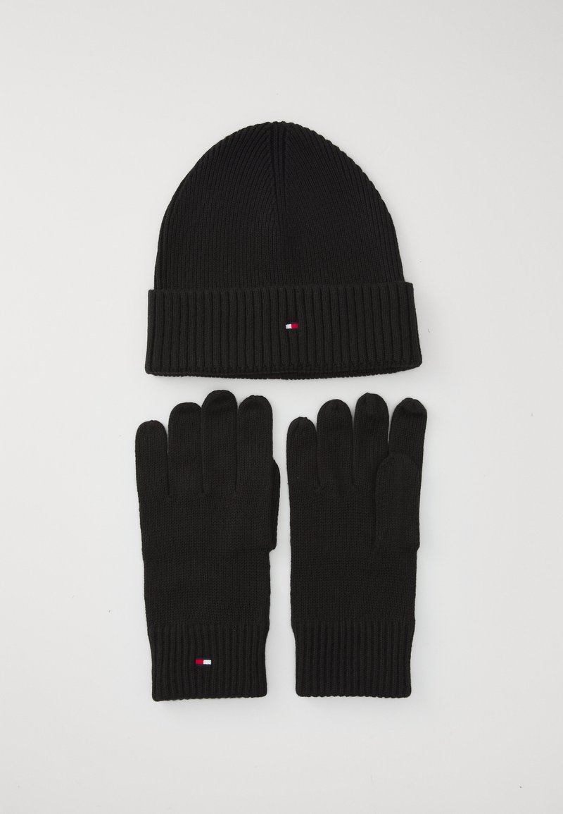 Bonnet en tricot noir avec un poignet côtelé et un petit logo, associé à des gants en tricot noir assortis avec des poignets côtelés.