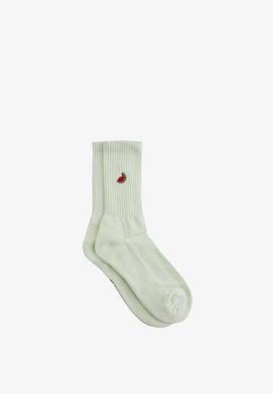 Hellgrüne gerippte Socken mit einem gestickten Design in Form einer Wassermelonenhälfte. Weicher Stoff und mittellange Form, geeignet für den Freizeitgebrauch.