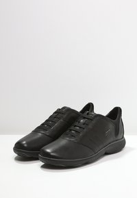Pantofi negri din piele cu un finisaj neted, design cu profil joasă și accente din plasă. Dispun de un sistem de închidere cu șireturi și o talpă căptușită pentru confort.