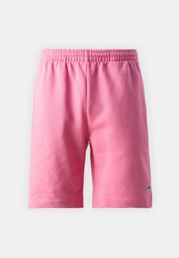 Różowe bawełniane szorty z elastycznym pasem, z obszytym dołem i małym zielonym logo w prawym dolnym rogu.