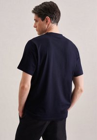 T-shirt in cotone blu navy con maniche corte e collo rotondo, caratterizzata da una texture liscia e un taglio dritto, vista di spalle.