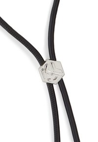 Black leather cords intersect at a silver hexagonal accent with a geometric design, emphasizing a sleek and modern construction.