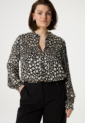 Zwarte en crème gestreepte blouse met een kraag, knoopsluiting aan de voorkant en lange mouwen. Gemaakt van gladde stof met een iets losse pasvorm.