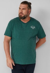 Donkergroene T-shirt met korte mouwen en een ronde hals, voorzien van een bedrukt logo op de linkerborst. Zacht, gestructureerd stof.