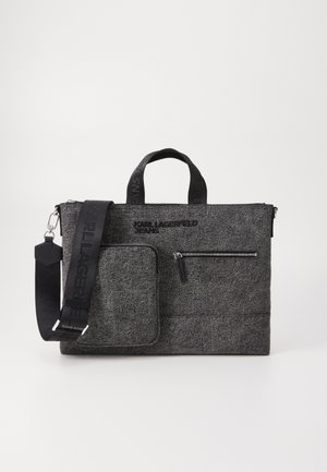 Grå stoffpose med teksturert overflate. Har to rom med glidelås, en avtagbar skulderrem og topphåndtak. Merkevaren er vist.