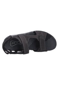 Sandalía negra con parte superior de ante, múltiples correas, costuras visibles y suela de goma a rayas diseñada para comodidad y soporte.
