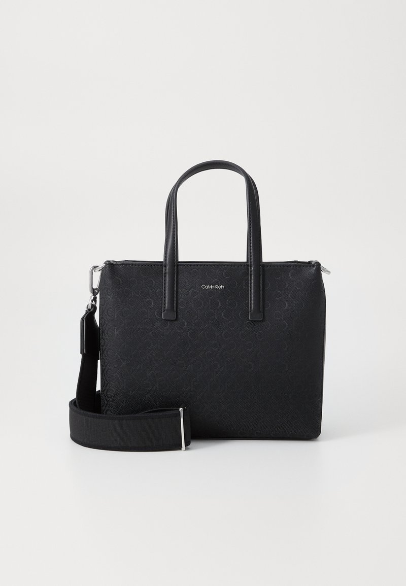 Black synthetic handbag with a rectangular shape, double top handles, and an adjustable strap. Features a textured logo pattern and silver hardware.