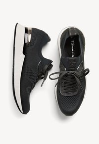 Chaussures de sport noires avec une tige en maille texturée, un col rembourré et des accents gris. Présente une semelle intermédiaire blanche et des lacets noirs.