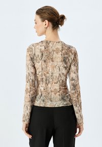 Langsleeve top in een slangenhuidpatroon, met een nauwsluitend ontwerp in gedempte beige, bruine en grijze tinten. Zachte textuur en ronde halslijn.