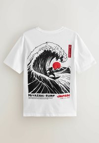 Biely tričko s čiernou grafikou surfistu jazdiaceho na veľkej vlne, červené slnko, japonský text a nápis "Miyazaki Surf Japan" vytlačený nižšie.