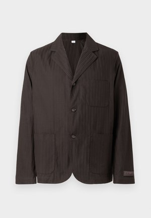 Veste blazer marron foncé à rayures fines verticales, coupe simple boutonnage, col à encoche, deux poches avant, et patch logo subtil sur la manche.