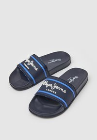 Chanclas azul marino hechas de material sintético con una tira ancha que presenta el texto blanco "Pepe Jeans London" y franjas de acento azules.