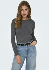 Gray long-sleeve top made of soft fabric, paired with high-waisted light blue jeans and a black belt featuring a gold buckle.