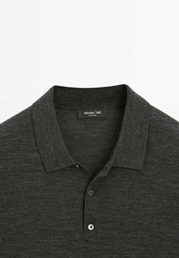 Polo grigio scuro con una texture morbida, dotato di colletto, chiusura a tre bottoni e etichetta con la scritta "Massimo Dutti."