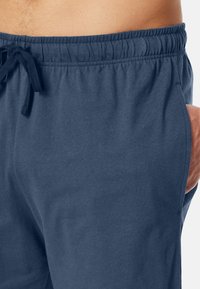 Marineblaue Shorts mit einem Kordelzugbund, seitlichen Taschen und weichem Baumwollstoff. Verfügt über eine glatte Textur und ein lässiges Design.