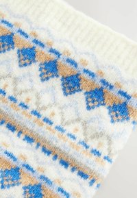 Gyapjútextil, amelynek fehér alapja kék és bézs geometrikus mintával díszített. Puha tapintású, bordás mandzsettával.