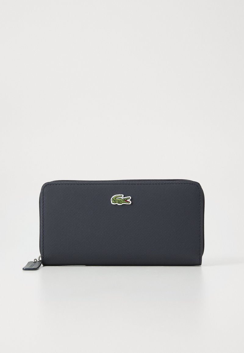 Navy blue textured zip wallet, featuring a small embroidered green crocodile logo. Rectangular shape with a smooth zipper closure.