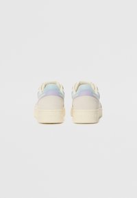 Sneakers with a dual-tone design, featuring light blue and lavender accents, a suede and leather upper, and a textured beige sole.