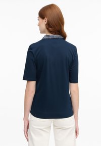 Marineblaue Polo-Shirt mit einem strukturierten karierten Kragen, kurzen Ärmeln und einer lockeren Passform. Glatte Stoff, keine sichtbaren Muster oder Akzente.