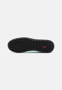 Nike shoe sole featuring a textured pattern with black rubber and a centered red Nike swoosh accent, designed for traction and stability.