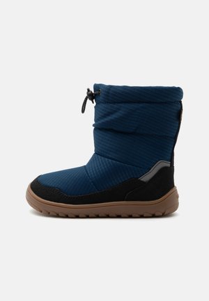 Botte d'hiver isolante bleue avec garniture noire, semelle en caoutchouc marron et fermeture à cordon ajustable en haut pour un maintien ajusté.