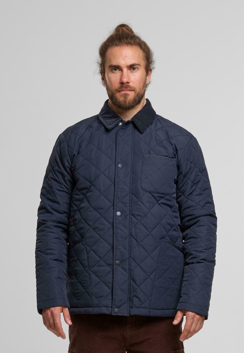 Dunkelblau gesteppte Jacke mit einem samtartigen Kragen, Vorderknöpfen und einer Brusttasche; verfügt über ein Diamantmuster und seitliche Taschen.