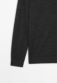 Dunkelgrauer Langarm-Pullover aus weichem Material. Enganliegende Bündchen und Saum mit einer glatten Textur. Minimalistisches Design ohne sichtbare Muster.