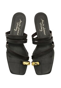 Sandalias negras de punta cuadrada con múltiples correas entrecruzadas y un hebilla dorada como acento. Textura de piel suave y suela plana.
