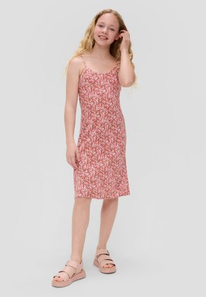 Robe rose à motifs floraux avec des fines bretelles, en tissu doux et d'une coupe mi-genou. Associée à des sandales rose clair à deux brides.