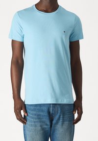 Jasnoniebieska bawełniana koszulka z krótkim rękawem i okrągłym dekoltem, z małym logo na piersi i luźnym krojem.