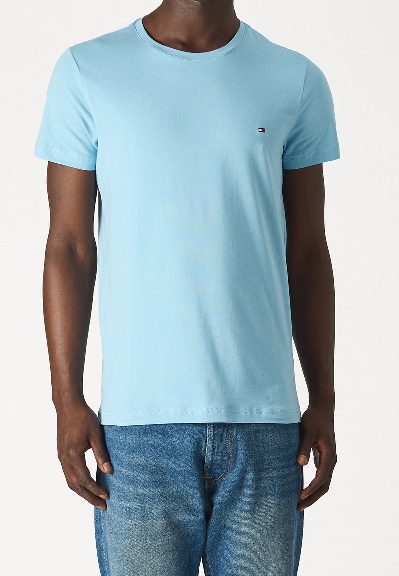 Jasnoniebieska bawełniana koszulka z krótkim rękawem i okrągłym dekoltem, z małym logo na piersi i luźnym krojem.