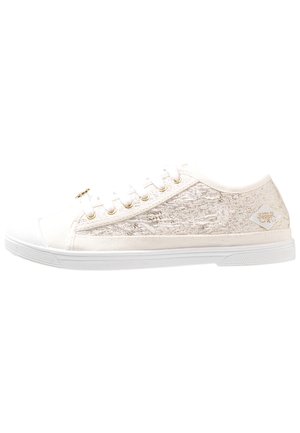 Witte canvas sneaker met metallic gouden accenten, ronde neus, vetersluiting en textuurpaneel aan de zijkant. Platte rubberen zool met minimaal loopvlak.