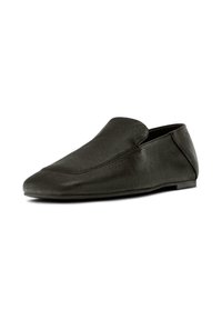 Scarpa slip-on in pelle nera con punta arrotondata, superficie testurizzata e design minimalista. Presenta un profilo basso e assenza di chiusure visibili.