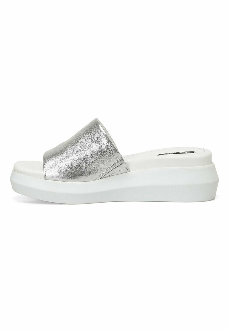 Zilveren metalen slide-on sandalen met een brede band, witte platformzool, gladde textuur en een minimalistisch ontwerp.