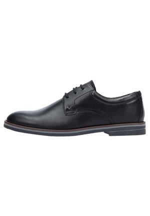 Zapato de vestir de cuero negro con un acabado suave, punta redonda, diseño con cordones y una entresuela marrón en contraste. Suela de goma de perfil bajo.