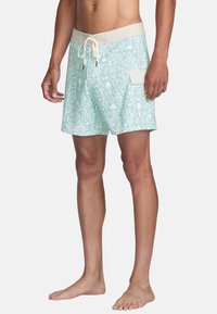 Mannen zwemshorts in muntgroen met een wit abstract patroon. Heeft een beige tailleband en een zijzak; gemaakt van lichtgewicht materiaal.