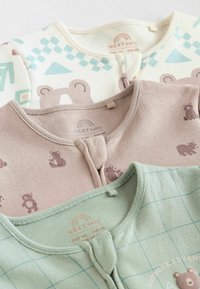 Trois tenues pour bébés : crème avec des motifs géométriques, beige avec des imprimés d'ours, et vert avec un quadrillage ; tissu en coton doux et encolures rondes.