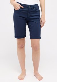 Shorts bleu marine en mélange de coton, avec une coupe ajustée, des poignets retroussés, des poches avant et une fermeture éclair avec un bouton.