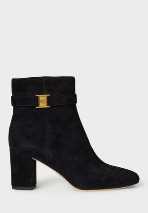 Stivale alla caviglia in suede nero con tacco a blocco, punta affusolata e dettaglio decorativo in oro attorno alla caviglia. Tessuto liscio in tutto.