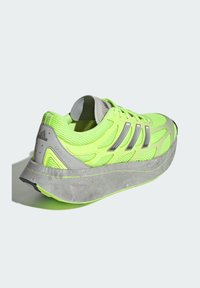 Neon zelene tenisice za trčanje s gornjim dijelom od mrežastog materijala, sivi detalji i debela pjena za potplat. Ima tri srebrne pruge i teksturirane detalje.