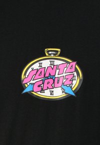 Svart T-skjorte med en rund grafikk av et klokke-design, "SANTA CRUZ" i rosa og blå tekst, omkranset av gult med romerske tall.
