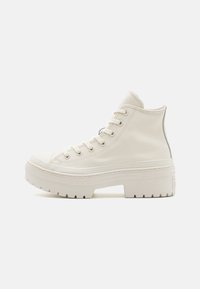 Sneaker alta in tela color avorio, con superficie testurizzata, suola piatta spessa e sei occhielli con lacci. Accento del logo discreto sul tallone.