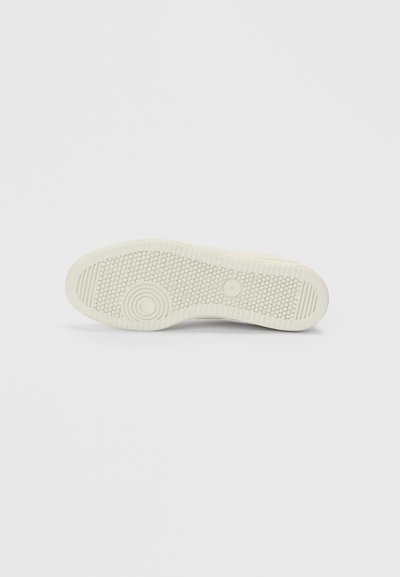 Baltā gumijas apavu zolīte ar teksturētu saķeres rakstu, riņķa akcentiem un paceltām līnijām. Gluda apdare ar nedaudz noapaļotu formu.