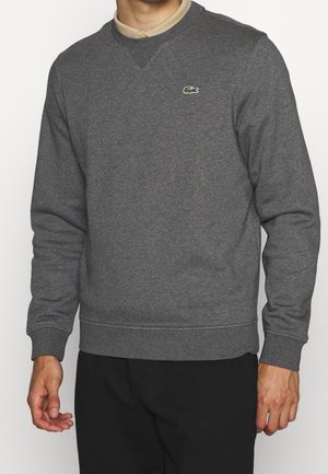 Sudadera gris de mezcla de algodón, con cuello redondo, puños y bajo acanalados, y un pequeño logo verde de Lacoste en el pecho.