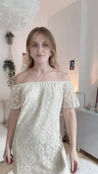 Vestido de renda off-the-shoulder em creme com mangas curtas com padrão floral e um corte descontraído. Textura leve, até ao joelho e com barra detalhada.