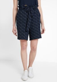 Granatowe szorty w białe grochy, z wysokim stanem, marszczoną elastyczną talią i paskiem wiązanym. Wykonane z lekkiego materiału.